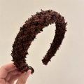 Primer plano de la diadema de punto marrón oscuro mostrando la textura de fibra suave - Marrón