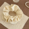 Elegante crème fluwelen scrunchie met ruches en zachte textuur op getextureerd papier - Off-wit