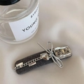 Detail of grey fabric hair clip with silver chain, heart charm and metal branding - Grey Chain Duckbill Clip