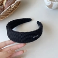 Dettaglio della fascia in maglia nera con texture intrecciata ed etichetta in tessuto - Nero