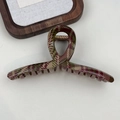 Detailed top view of a large red and green plaid hair claw clip on a white surface - Cross Light Plaid