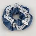 Détail du chouchou en velours bleu foncé avec dentelle à cœurs blancs et étiquette - Chouchou Bordure Dentelle Bleue