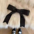 Gros plan sur le grand nœud en tricot gris foncé sur une surface de tapis en peluche - gris foncé