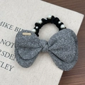 Detail of grey wool bow hair tie with elegant white faux pearls and gold charm accessory - Gray