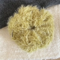 Detail of plush mustard green scrunchie with marea label on soft faux fur texture - Green