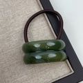 Detail of high-elasticity hair tie with dark green resin beads on linen tray texture - Double Arc Green