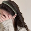 Detalle de una diadema de terciopelo verde oscuro acolchada usada por modelo - verde oscuro