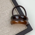 Close-up of minimalist resin hair tie with amber geometric curved accent and elastic band - Double Arc Coffee
