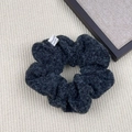 Detail of dark grey plush scrunchie with soft faux lamb wool texture and small woven label - Hair Tie / Dark Gray