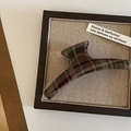 Dettaglio della pinza per capelli a quadri rossi e verdi su una scheda decorativa - Stile Appendiabiti Plaid Scuro