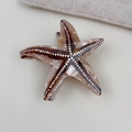 Dettaglio della molletta per capelli a stella marina marmorizzata con molla dorata - Forma a stella marina / Stella marina color caffè
