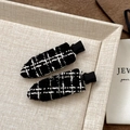 Dettaglio macro di fermagli per capelli in tweed bianco e nero con eleganti fili d'oro - Nero