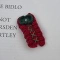 Detailed close-up of a handmade crochet Christmas tree hair clip with white pearl detail - Green Bow