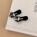 Détails de deux barrettes à cheveux en tweed à carreaux noir et blanc sur un livre - Pince à Cheveux Cœur Noir