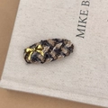 Détail de la barrette à carreaux en tweed avec un élégant nœud doré en métal poli - Pince à Cheveux Ovale Café