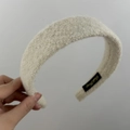 Détail du serre-tête en peluche blanc cassé avec étiquette de marque tissée - Blanc Cassé