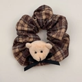 Detail of checkered fabric scrunchie with plush bear head and black silk ribbon bow - Brown Plaid