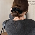 Macro shot of a large black velvet bow hair tie styling a high bun on a model back view - Black