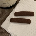 Dettaglio di un paio di fermagli per capelli marroni rettangolari in tessuto lavorato - Marrone