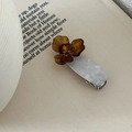 Dettaglio di un fermaglio per capelli a forma di iris con petali ambra e marmo bianco - Fiore Marrone Cachi Su Base Bianca