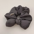 Close-up of charcoal gray bubble cotton scrunchie with handmade label detail - Bow Scrunchie / Gray