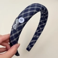 Detail eines marineblauen Karo-Haarbandes mit Hand Made Label und blauem Knopfakzent - Karo Stirnband