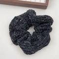 Detail eines dunkelgrauen Strick-Haargummis mit bunten Tweed-Fasern für Damenhaare - Schwarzes Haargummi