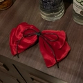 Detailed view of vintage burgundy velvet bow hair clip on a dark rustic wooden surface - Red