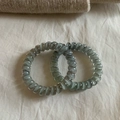 Close-up of grey-green spiral telephone wire hair ties with marble texture effect - Grey Blue