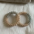 Detailed macro of two-tone spiral hair coils in grey-blue and beige resin material - Gradient Apricot Orange