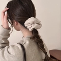 Detail van een oversized beige fluwelen scrunchie voor een stijlvolle paardenstaart - Abrikoos
