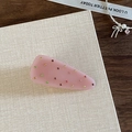 Dettaglio di fermaglio rosa triangolare con strass colorati su biglietto decorativo - Rosa