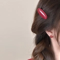 Detail of red vintage acetate hair clip and matching knot earrings on a model - Oval Clip And Stud Earrings