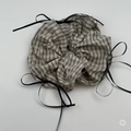 Detailansicht eines großen karierten Haargummis mit schwarzen Bändern und Retro-Muster - Beige Scrunchie