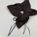Detailaufnahme eines braun-karierten Scrunchies mit langer schwarzer Bandschleife - Kaffeebraunes Karo Tuch Haargummi