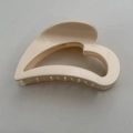 Detailed top view of the cream heart-shaped hair claw clip with smooth resin finish - Off-white