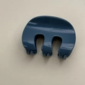 Draufsicht auf eine glänzende dunkelblaue französische Haarklammer im M-Design - Blau