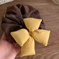 Detailansicht von dunkelbraunem und ingwergelbem Stoff-Haargummi mit großer Schleife - Gepolsterte Schleife (Gelb) / Gelb
