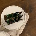 Detailed macro view of the tortoiseshell acetate hair claw with golden French logo - Dark Green Marble
