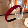 Detail of burgundy velvet headband with silver metal studs displayed on a glass - Burgundy