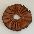 Detalle de un coletero de satén marrón caramelo con bordes de color café oscuro - Naranja