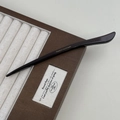 Detail view of acetate hair stick with gold France Handmade logo on jewelry box - Brown