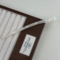 Elegant white acetate hair pin with pearlescent texture on a brown display case - Mermaid Color