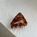 Macro shot of French acetate triangle hair claw clip in amber tortoise shell pattern - Amber Brown