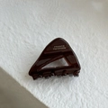 Detailed macro view of dark brown acetate triangle hair claw with silver handmade text - Chocolate