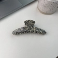 Grosse pince à cheveux crème avec motif à pois noirs posée sur un bureau blanc - Croissant de lune