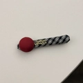 Détail de la boule en tissu rouge et barrette à carreaux avec inscription dorée - Pince à Cheveux Boule Rouge