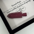 Macro di un fermaglio per capelli bordeaux opaco su una confezione regalo vintage - Rosso Vino Scuro