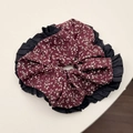 Dettaglio dello scrunchie floreale bordeaux con bordo plissettato nero e tessuto morbido - Elastico Rosso