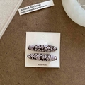 Dettaglio di fermagli per capelli in tessuto floreale vintage su carta fatta a mano - Stile Foglia